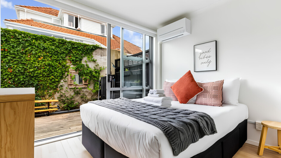 The bedroom features a cosy queen bed dressed in fresh linens and an ample closet space