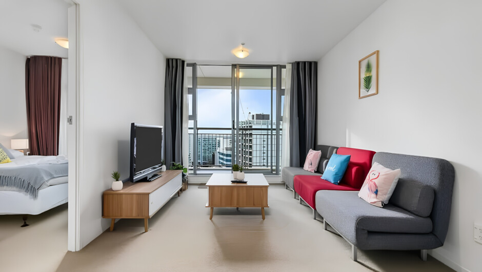 This bright living area features a comfortable sofa, a Smart TV, and is near a 4-seater dining table.