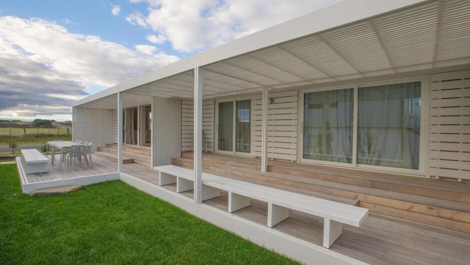 The covered veranda and lawn - outdoor seating with views across to the lake