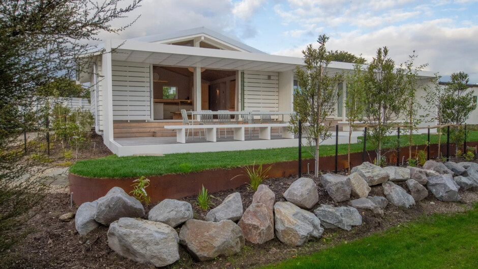 Landscaped gardens and native planting surround the bach