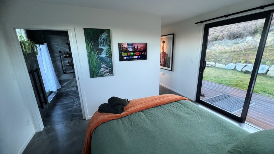 Bedroom with king bed &amp; TV, artwork, and beautiful private views