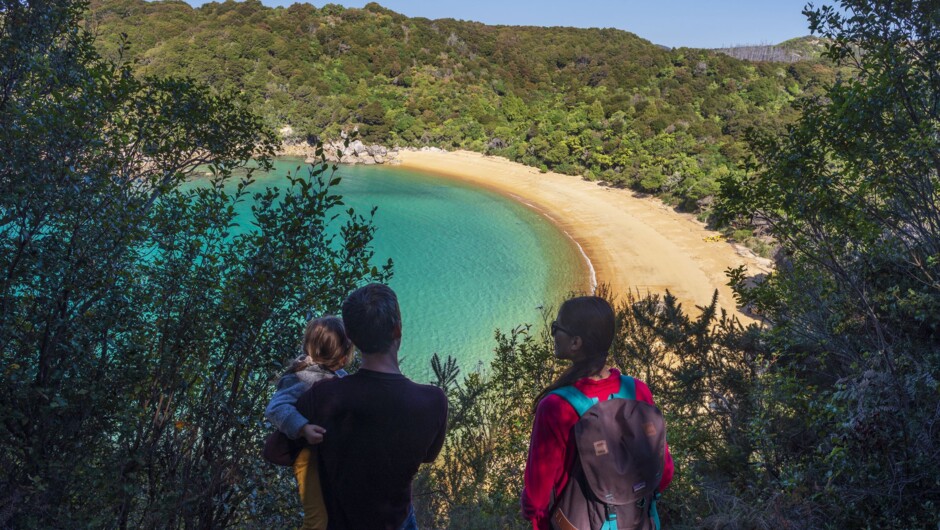 Family walking at Te Puketea in Abel Tasman National Park.