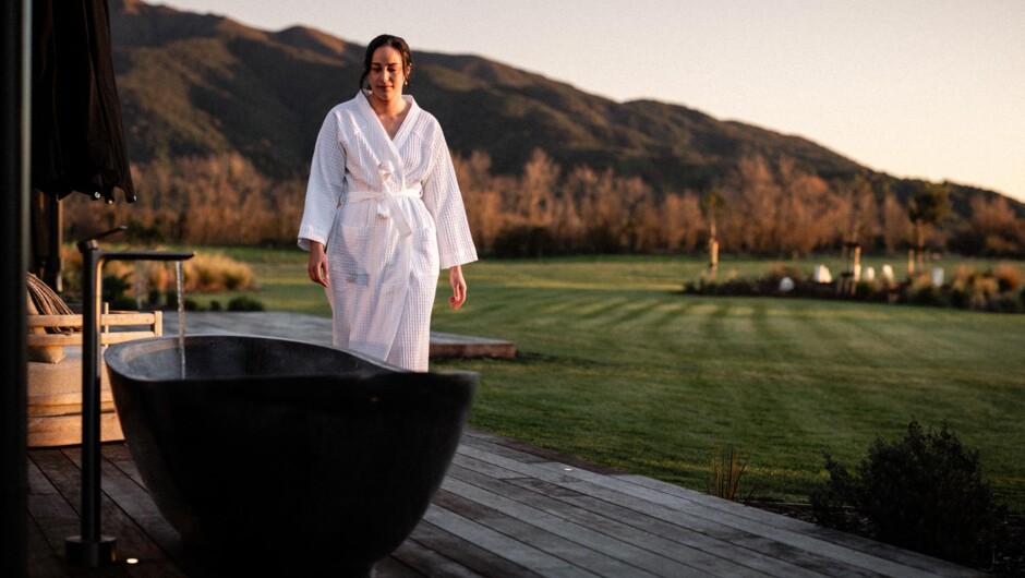 Relax in the outdoor bath and watch the sun move over Mt Peel.