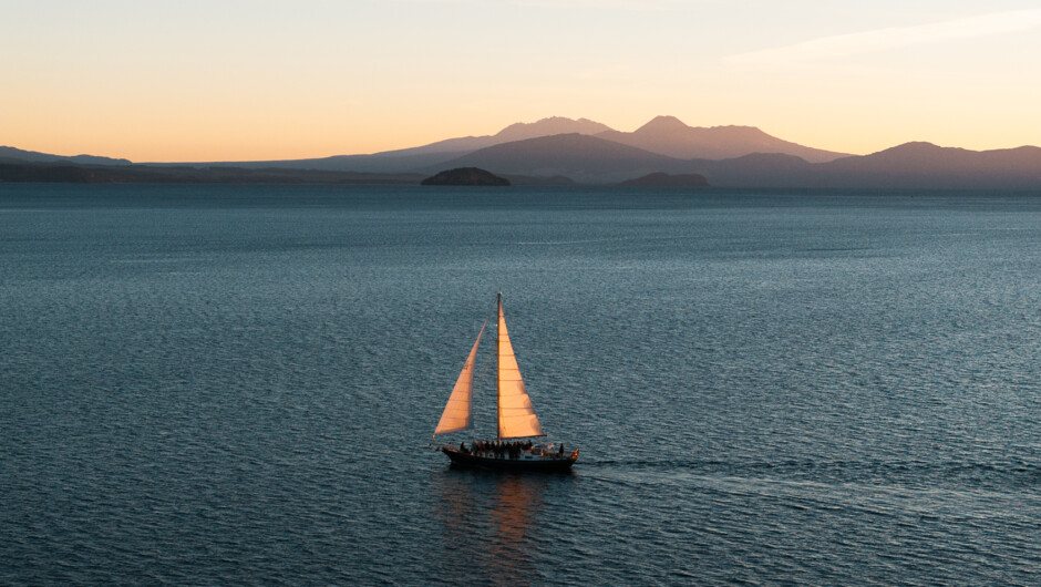 Across Lake Taupō on Fearless at sunset. Mount Ruapehu, Mount Ngauruhoe and Mount Tongariro in the background.
