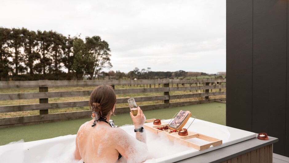Stargaze in the outdoor bath. Taranaki skies are made for this. Run a bath outside, sink in with the bath salts provided, and watch the stars come out over the paddocks.
