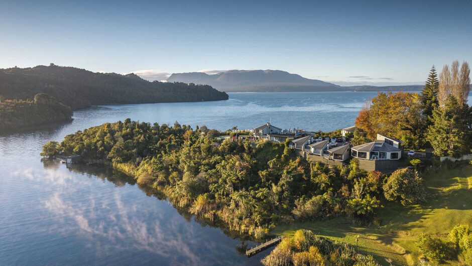 Solitaire Lodge enjoys breathtaking views from a private peninsula over Lake Tarawera, lush natural bush setting and dramatic volcanic backdrop.