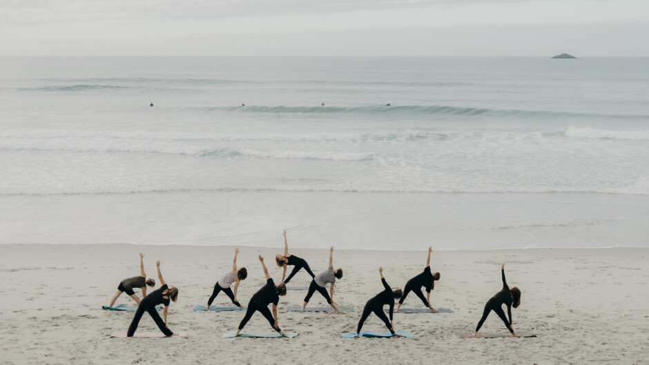 Sunrise Yoga on St Clair Beach, Dunedin. Surfers and White Island in the background.