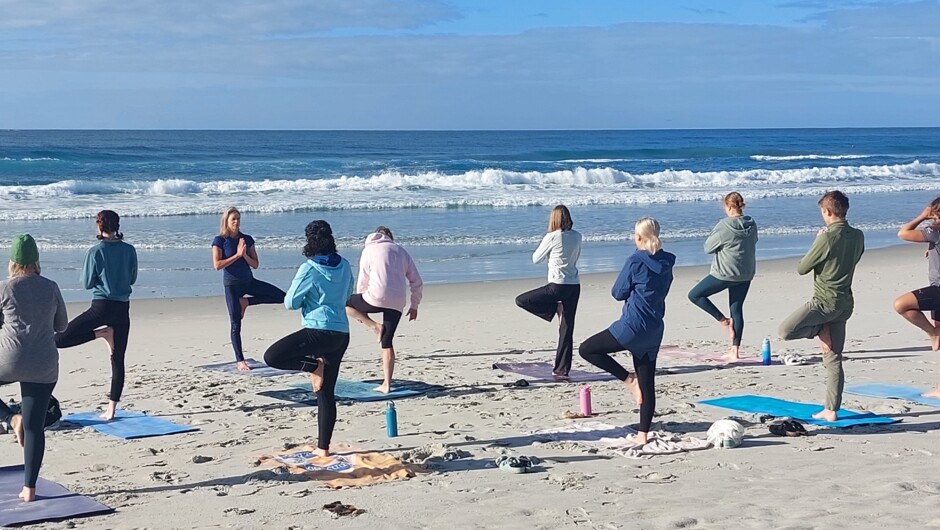 Improve balance and stability with Tree Pose on the sand, while listening to your body and enjoying the beauty of St Clair Beach.