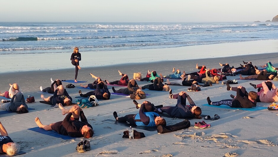 Sunrise Yoga on St Clair Beach during the Wild Dunedin New Zealand Festival of Nature. Warming up the hips, glutes and core in the morning sunshine.
