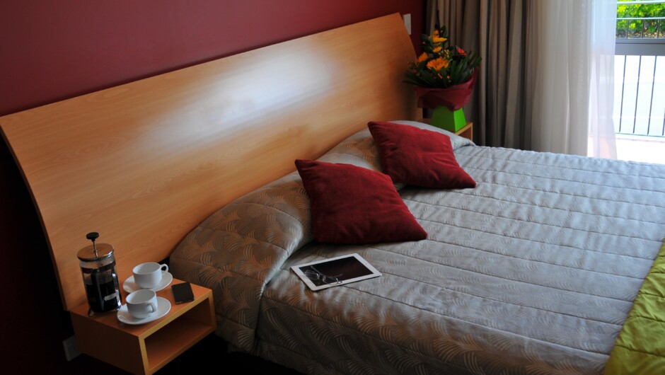 All units have large king-size beds with modern decor and air conditioning.