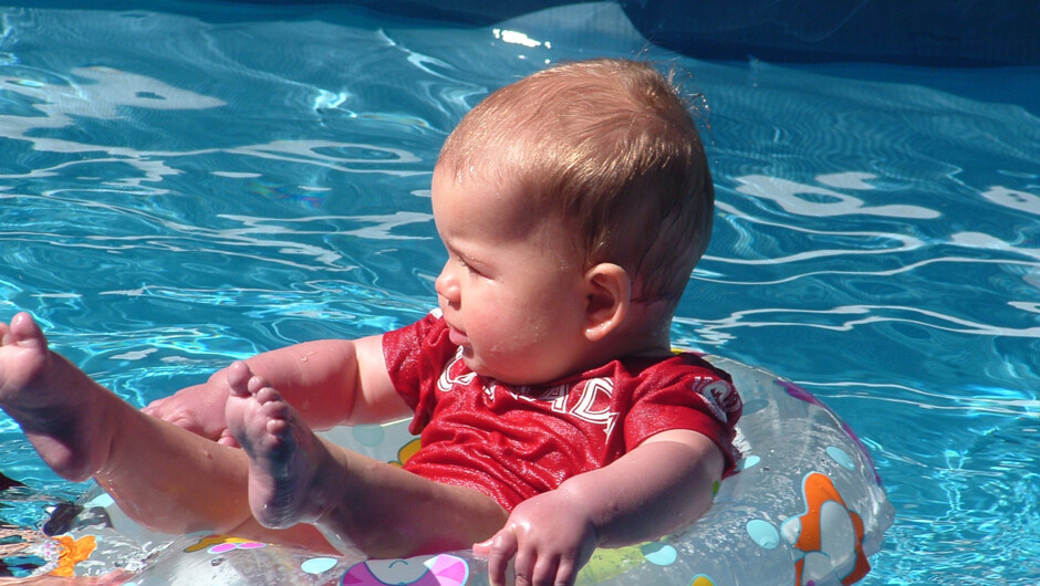 Guest outdoor pool in the summer beside a barbecue area.