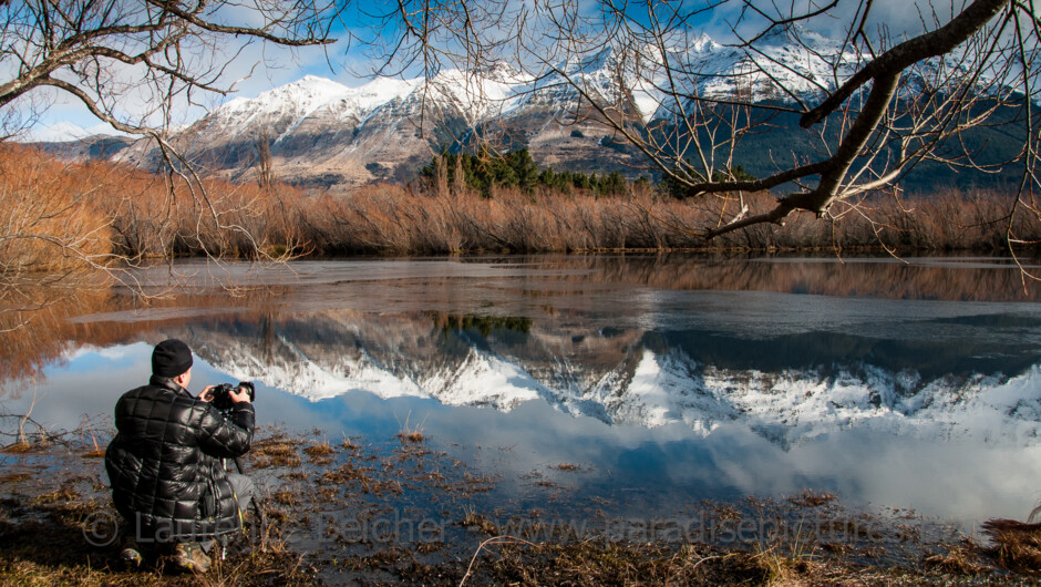 Photographing the calm water in the Glenorchy Lagoon looking across to the Humboldt Range in the distance.