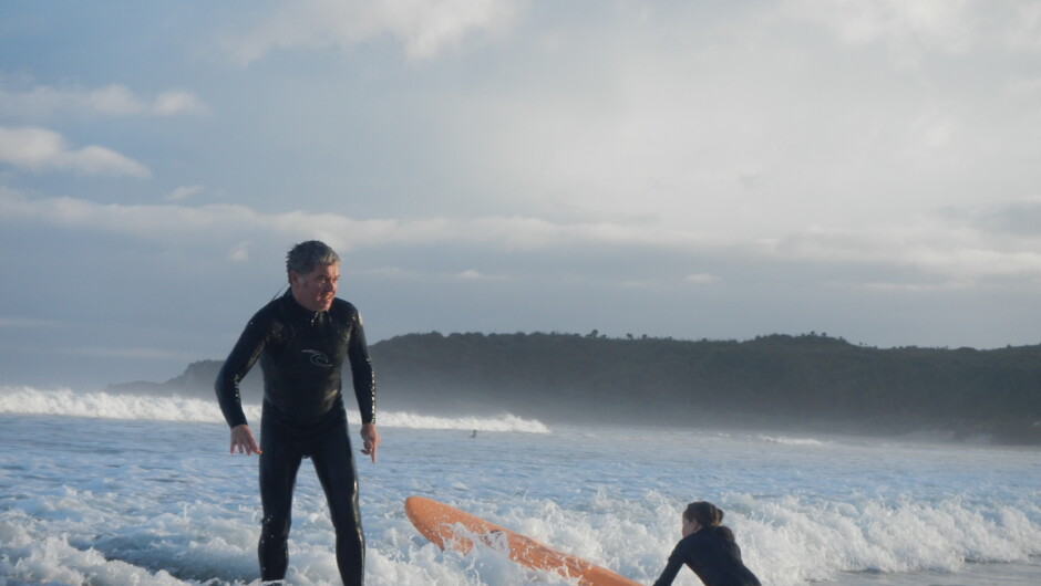 father and daughter surfing together