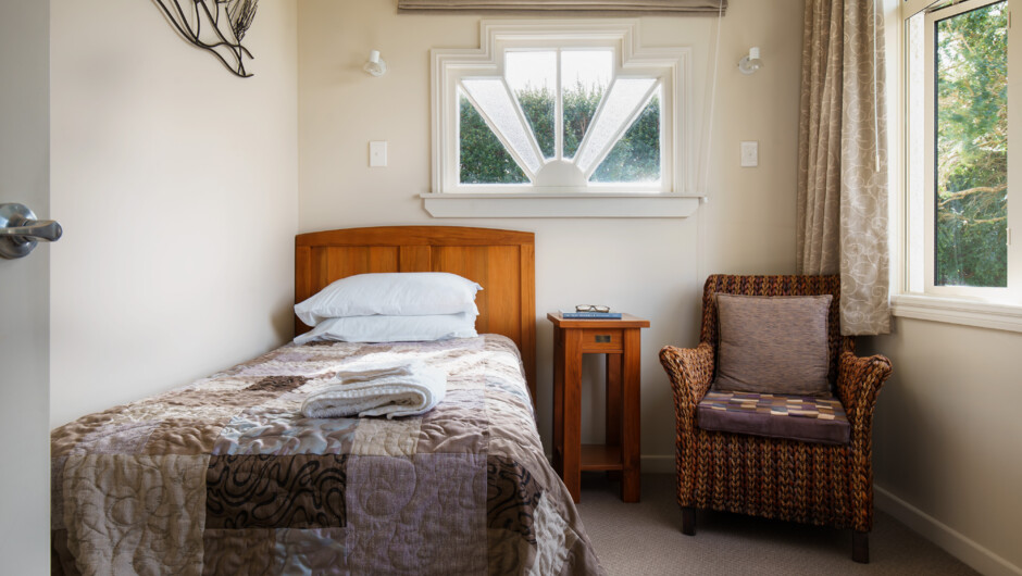 The front bedroom has a king single bed and a view of the large front garden.