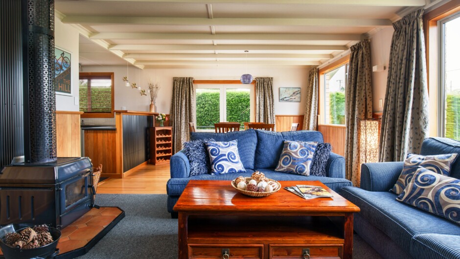 Plush furniture around the wood burner in an open plan living space.