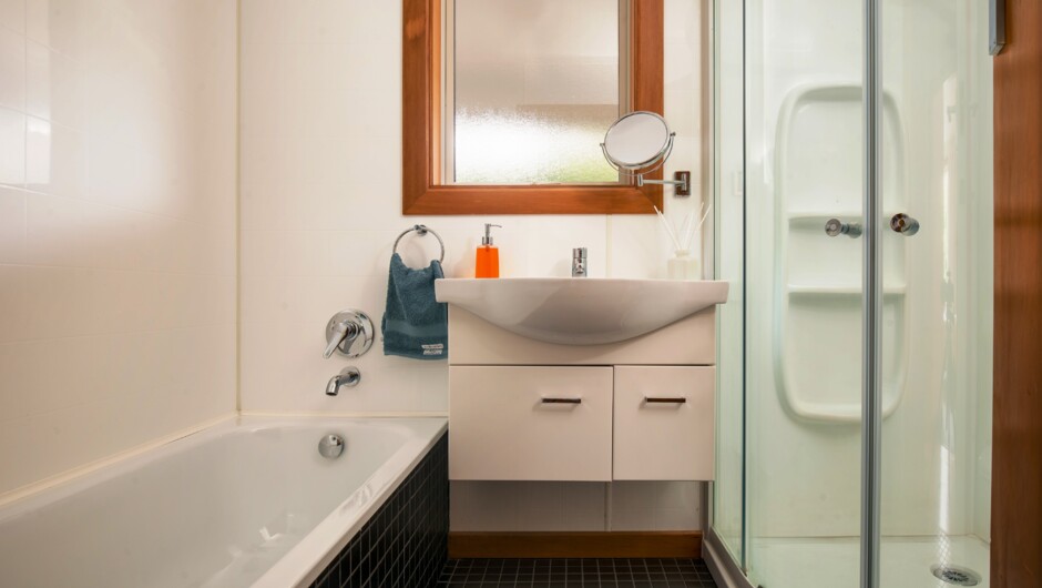 A bath, shower, basin and toilet are all set in a new bathroom.