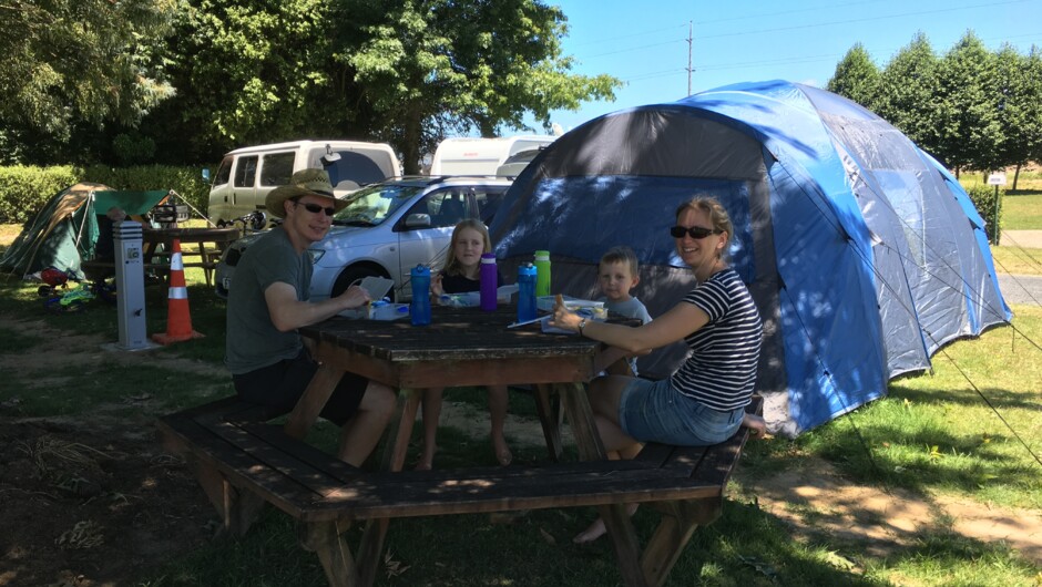 Family camping enjoying the shade under our large shade trees.