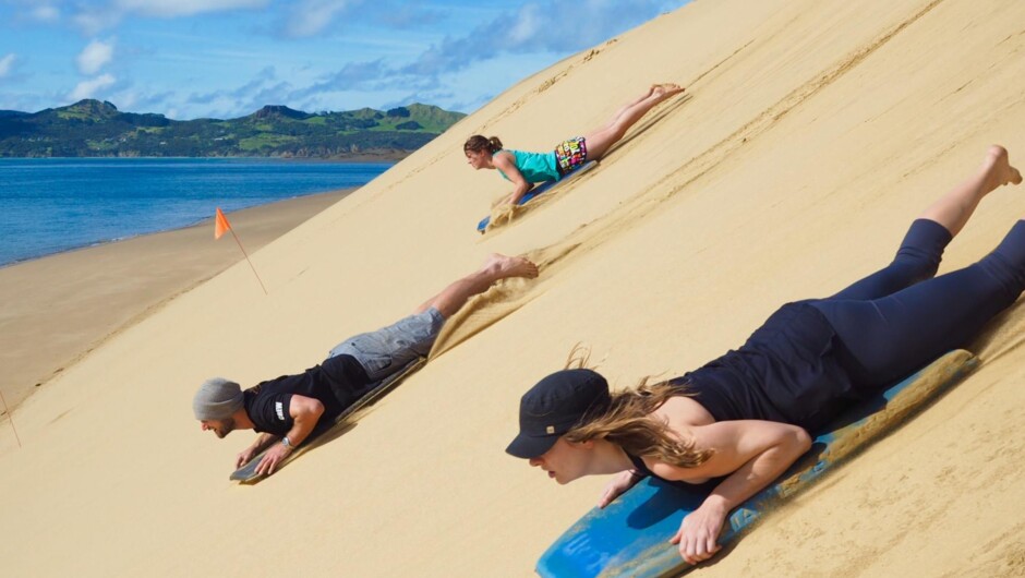 Sandboarding down the dunes of Opononi